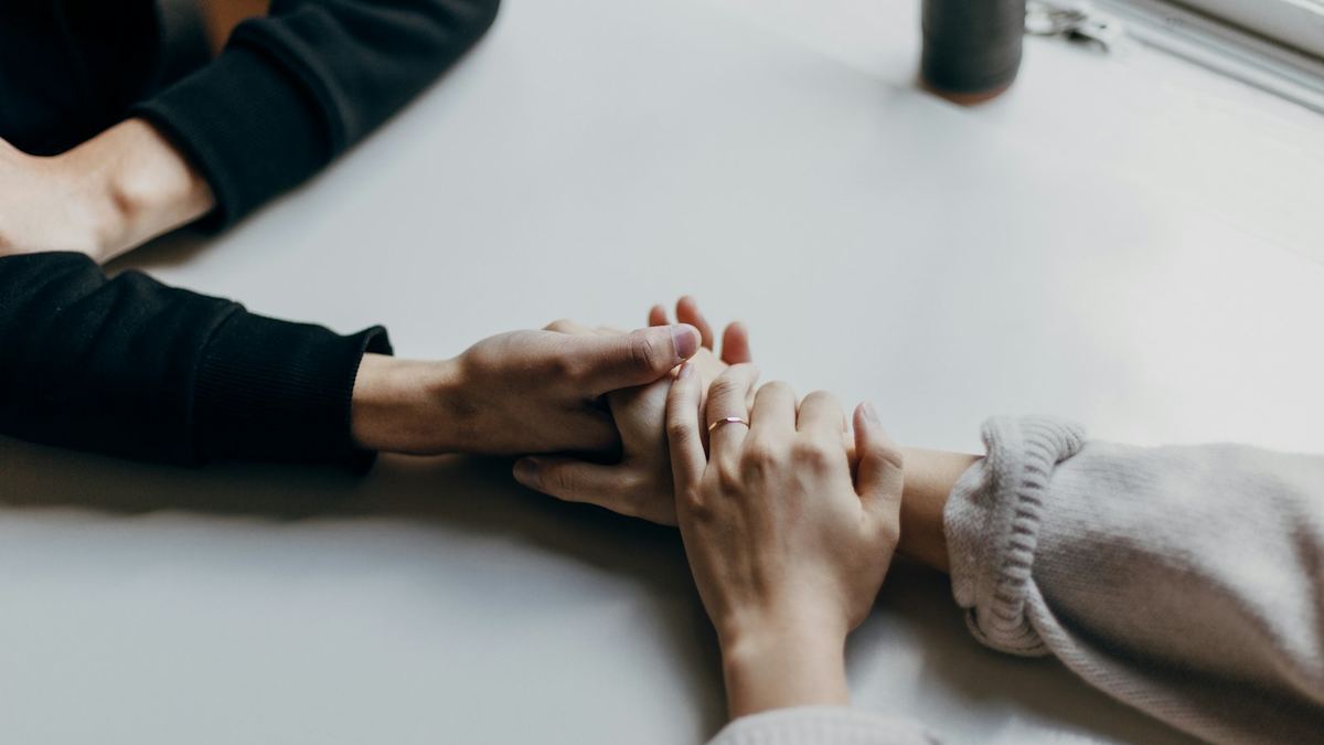 Deux personnes se tenant la main sur une table
